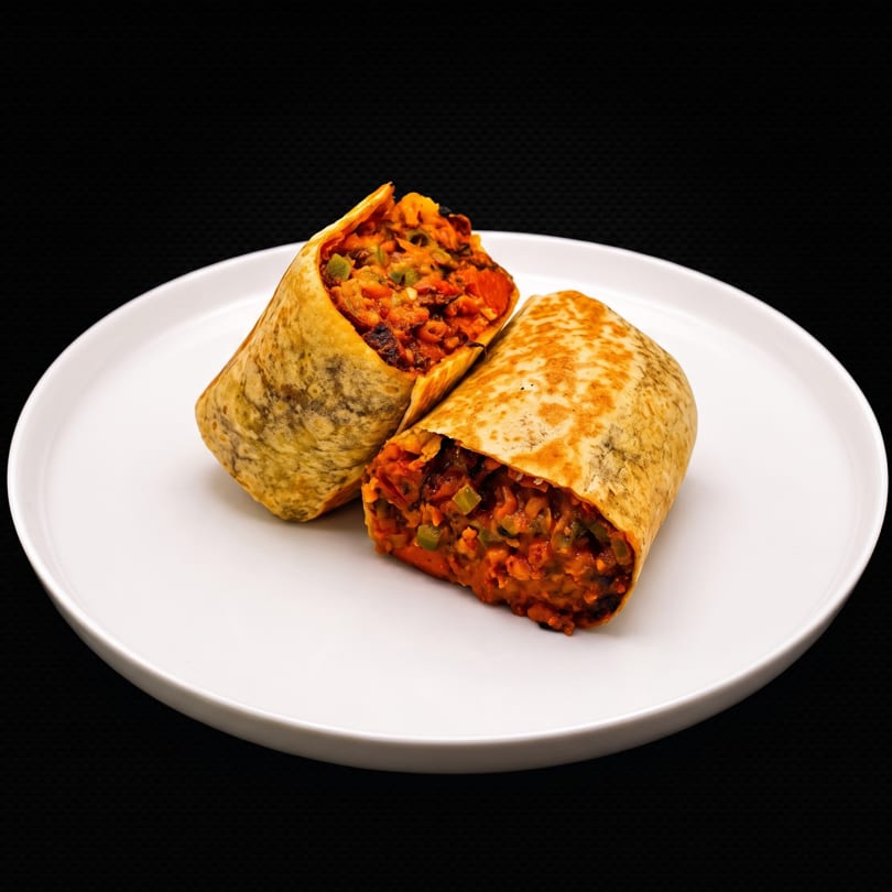 Two halves of a burrito, filled with rice and vegetables, on a white plate.